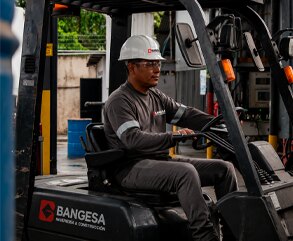 Operador conduciendo un montacargas en instalaciones industriales